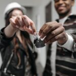 Junges Paar mit Schlüsseln in einer leeren Wohnung