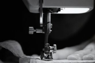 bernina - Detailed grayscale image of a sewing machine needle threading fabric, showcasing craftsman