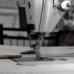 bernina - Closeup of an industrial sewing machine in a textile factory, focused on needle and fabric