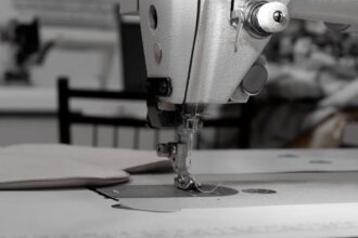 bernina - Closeup of an industrial sewing machine in a textile factory, focused on needle and fabric