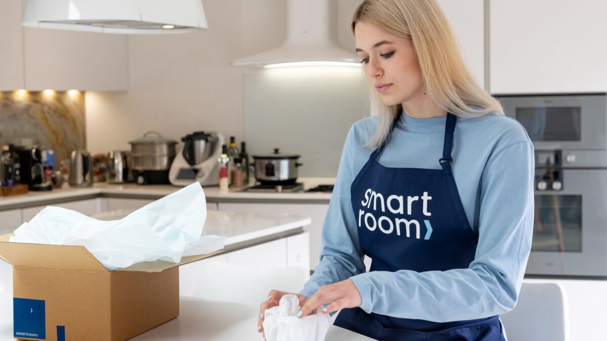 Frisch geliefertes Gerät steht neben dem geöffneten Karton im Wohnzimmer