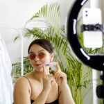 imke riedebusch - Fashion vlogger showcasing a cosmetic product with a smartphone and ring light set