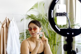 imke riedebusch - Fashion vlogger showcasing a cosmetic product with a smartphone and ring light set