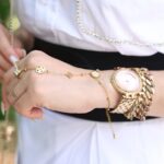 juwelier rieger - Close-up of a woman's wrist with elegant gold jewelry, showcasing style and luxury