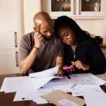 Paar am Küchentisch rechnet die Finanzierung für eine Wohnung durch