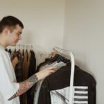 walbusch solingen - Two young men browsing clothes on racks in a trendy boutique store setting.