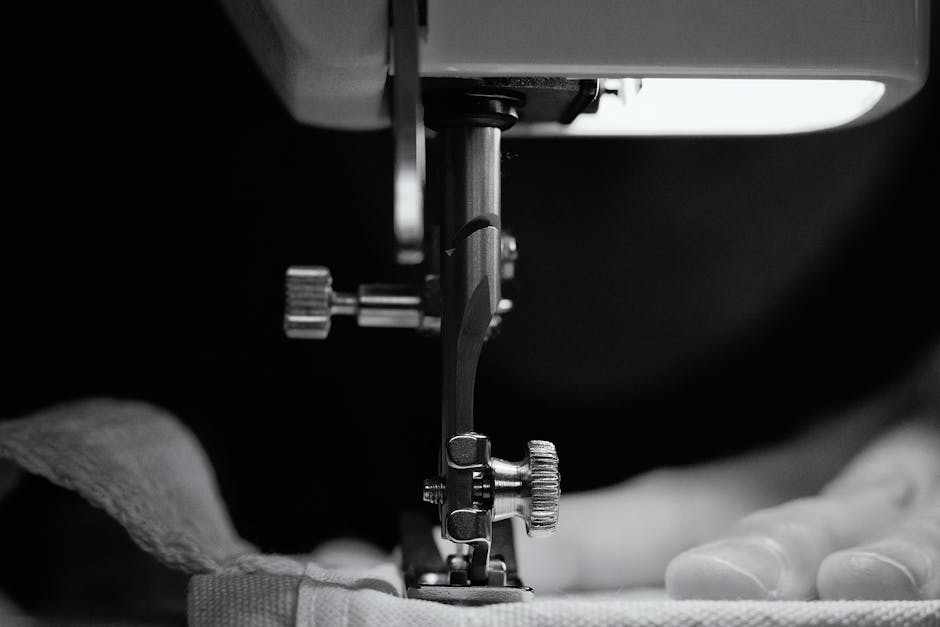bernina - Detailed grayscale image of a sewing machine needle threading fabric, showcasing craftsman